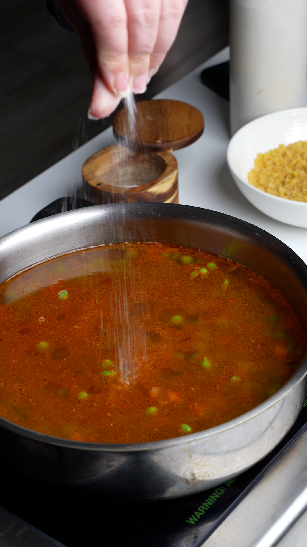 Process photo on how to make pasta e piselli - pancetta, onions, peas, tomato paste and water in a pan