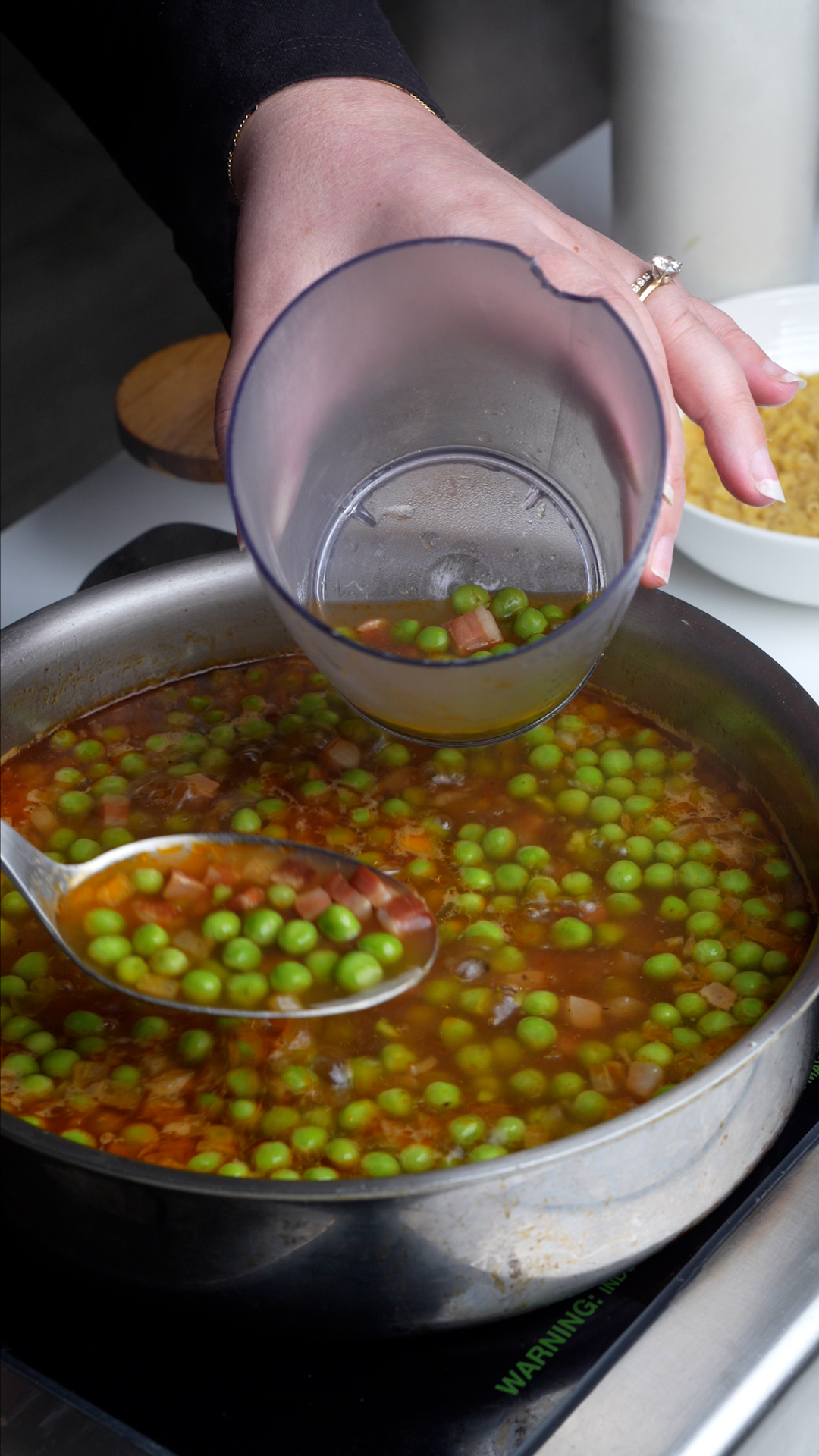 Process photo on how to make pasta e piselli - pasta e piselli mixture being put into a bleding canister