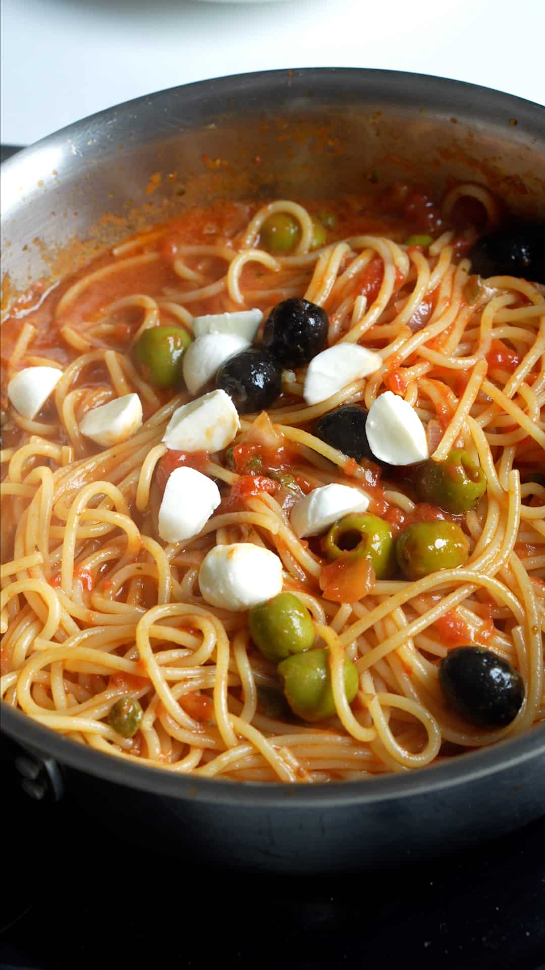 Step by step process on how to make vesuviana pasta - cooked pasta in sauce with mozzarella