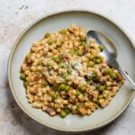 Plate of pasta e piselli with a spoon in it