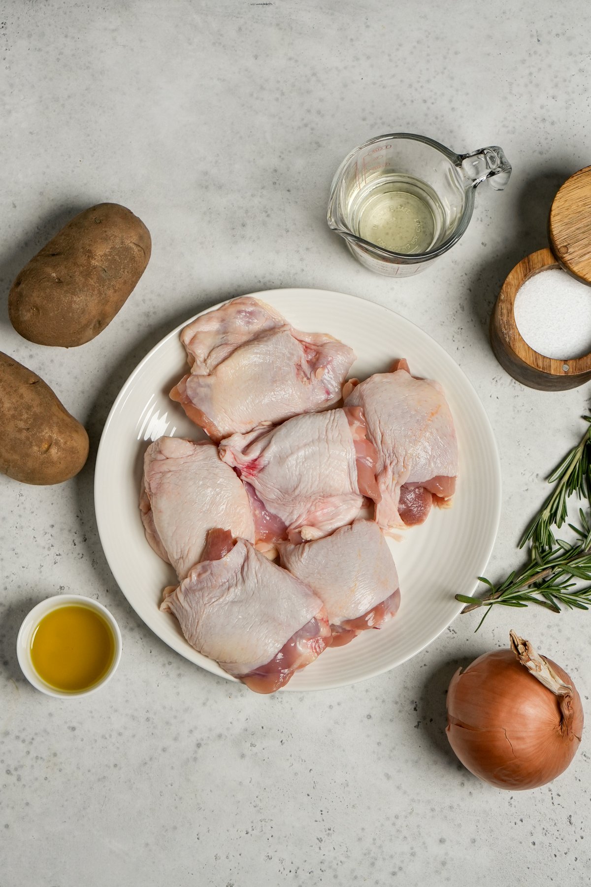 Ingredients for Italian baked chicken - chicken thighs, white wine, salt, rosemary, onion, olive oil, potatoes