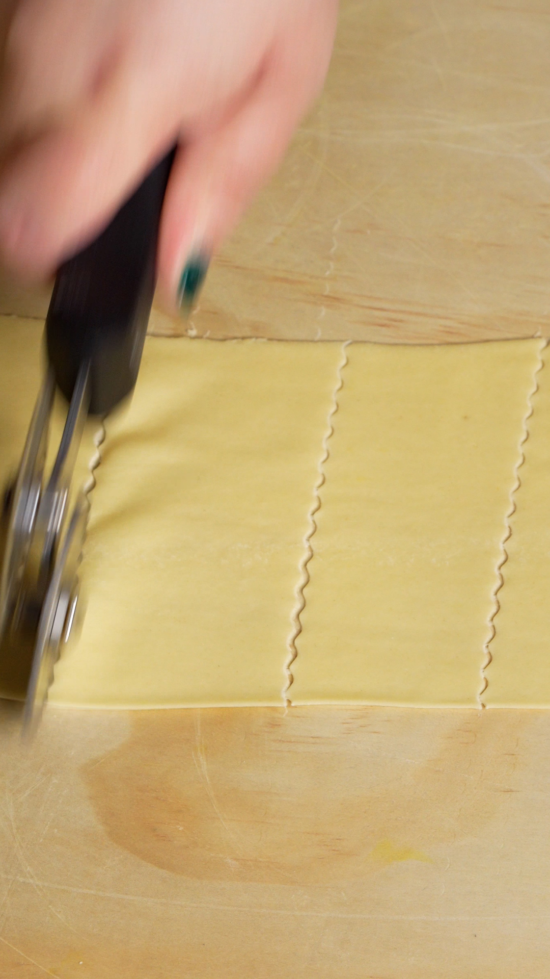 Dough being cut with pastry wheel