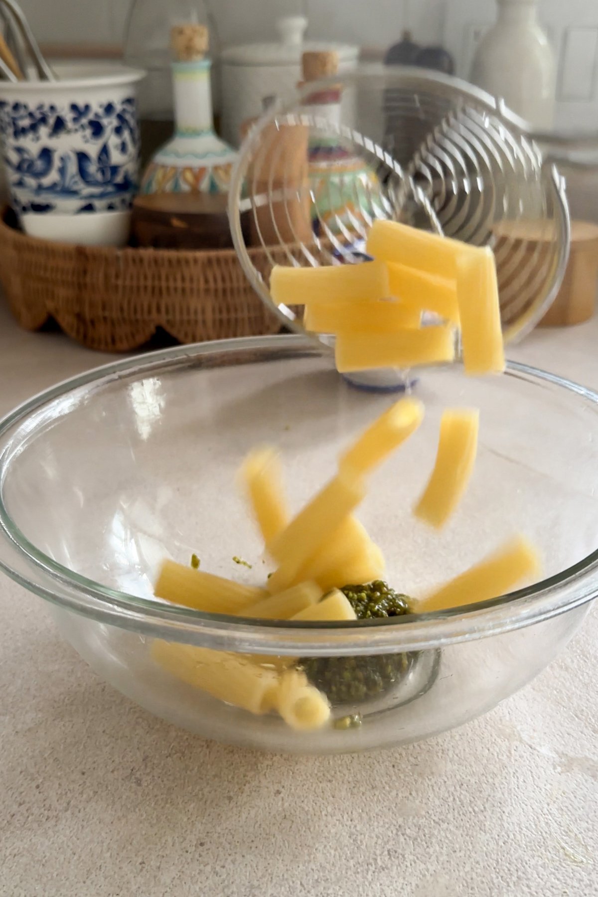 Rigatoni pasta being put into a bowl