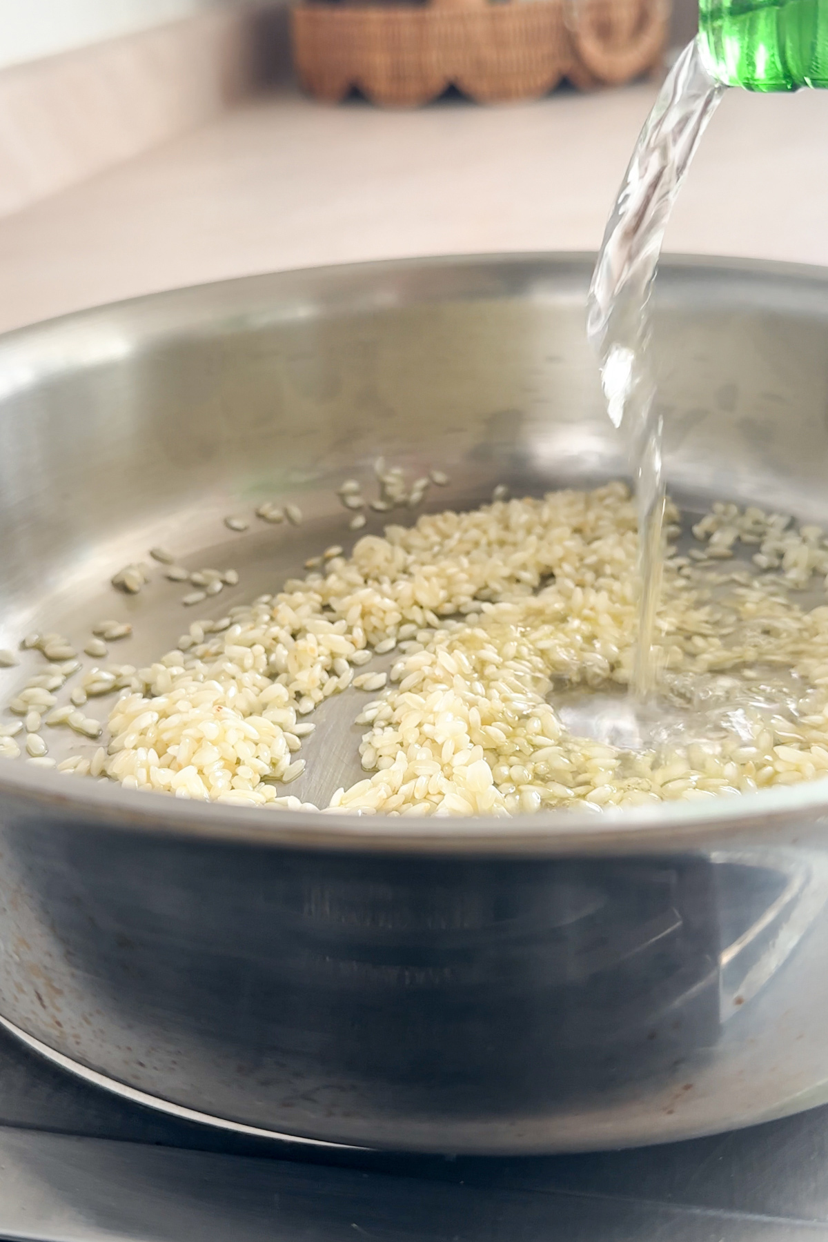 White wine being poured into a pan with rice