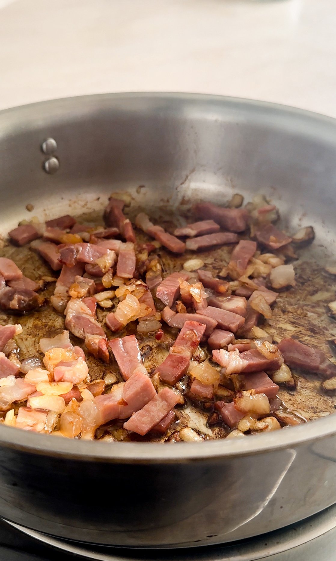 Cooked prosciutto and peas in a pan