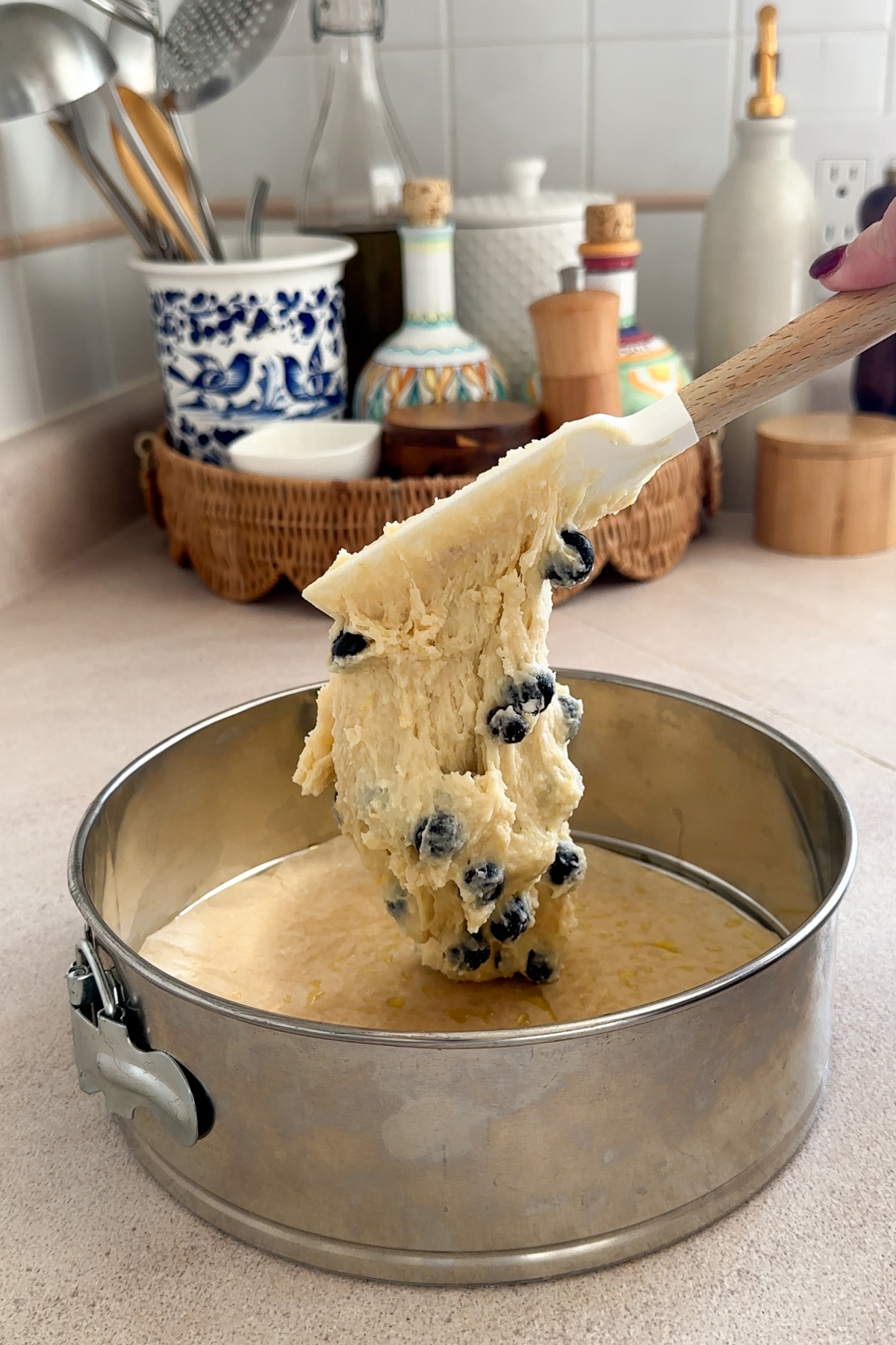 cake batter being spooned into springform cake pan