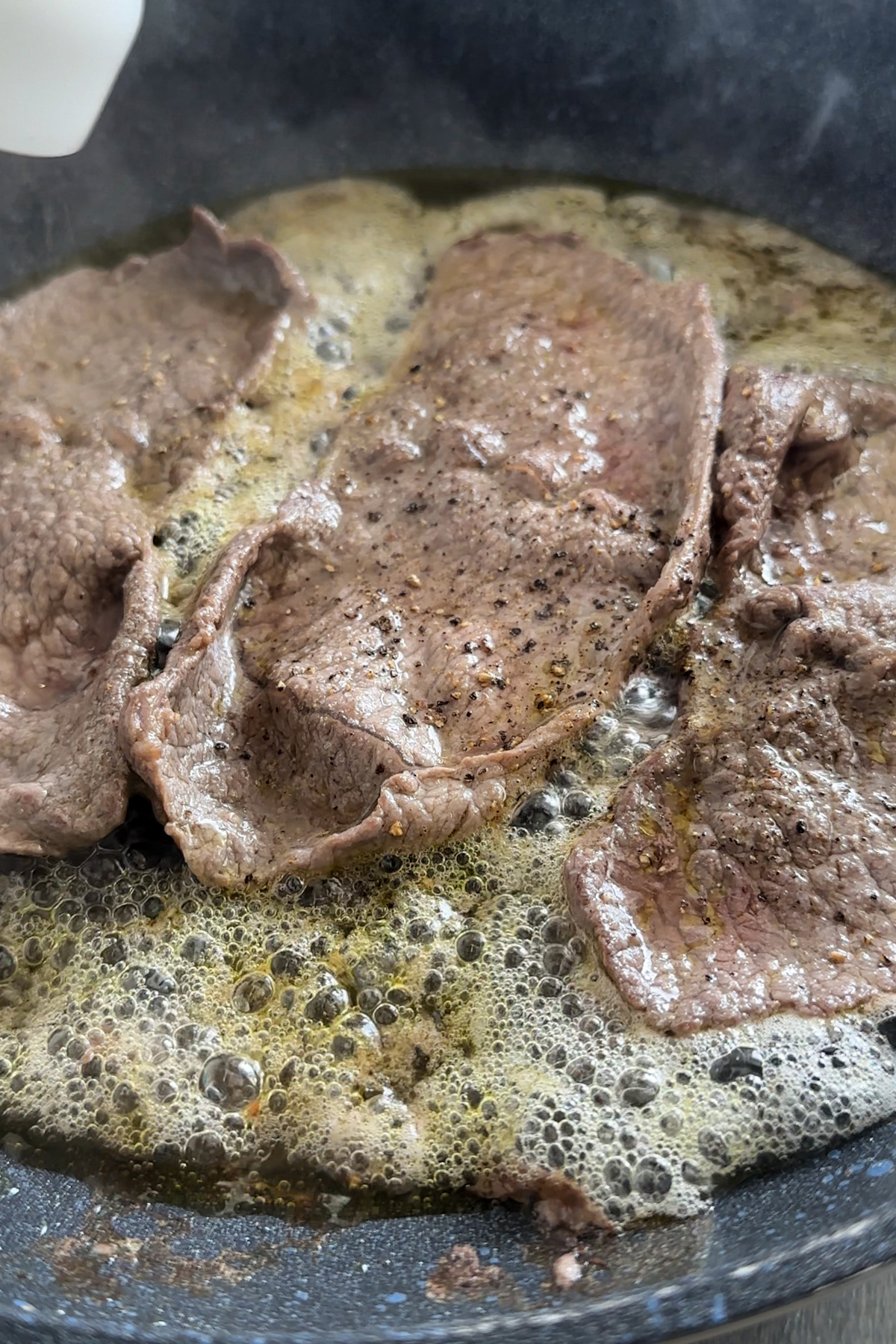 Cooked thin cut sirloin steaks in a pan