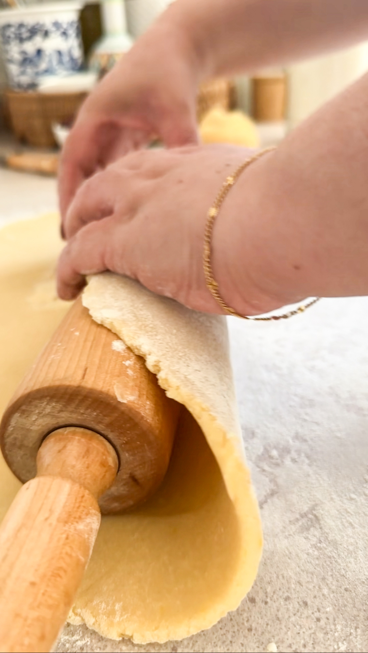 Crostata dough being rolled onto a rolling pin