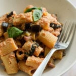 eggplant and ricotta pasta in a dish topped with fresh basil leaves