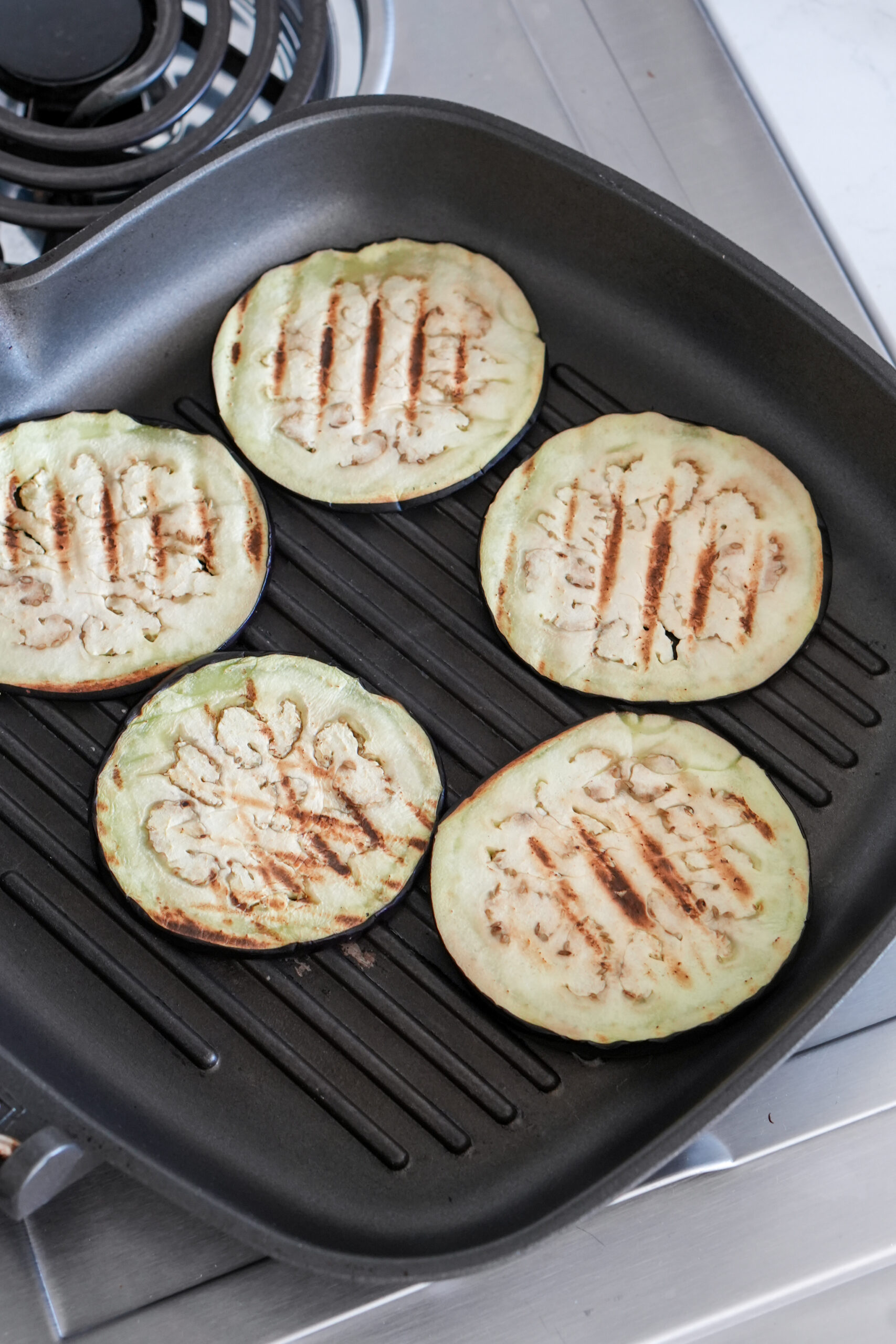 Eggplant being grilled in a grill pan