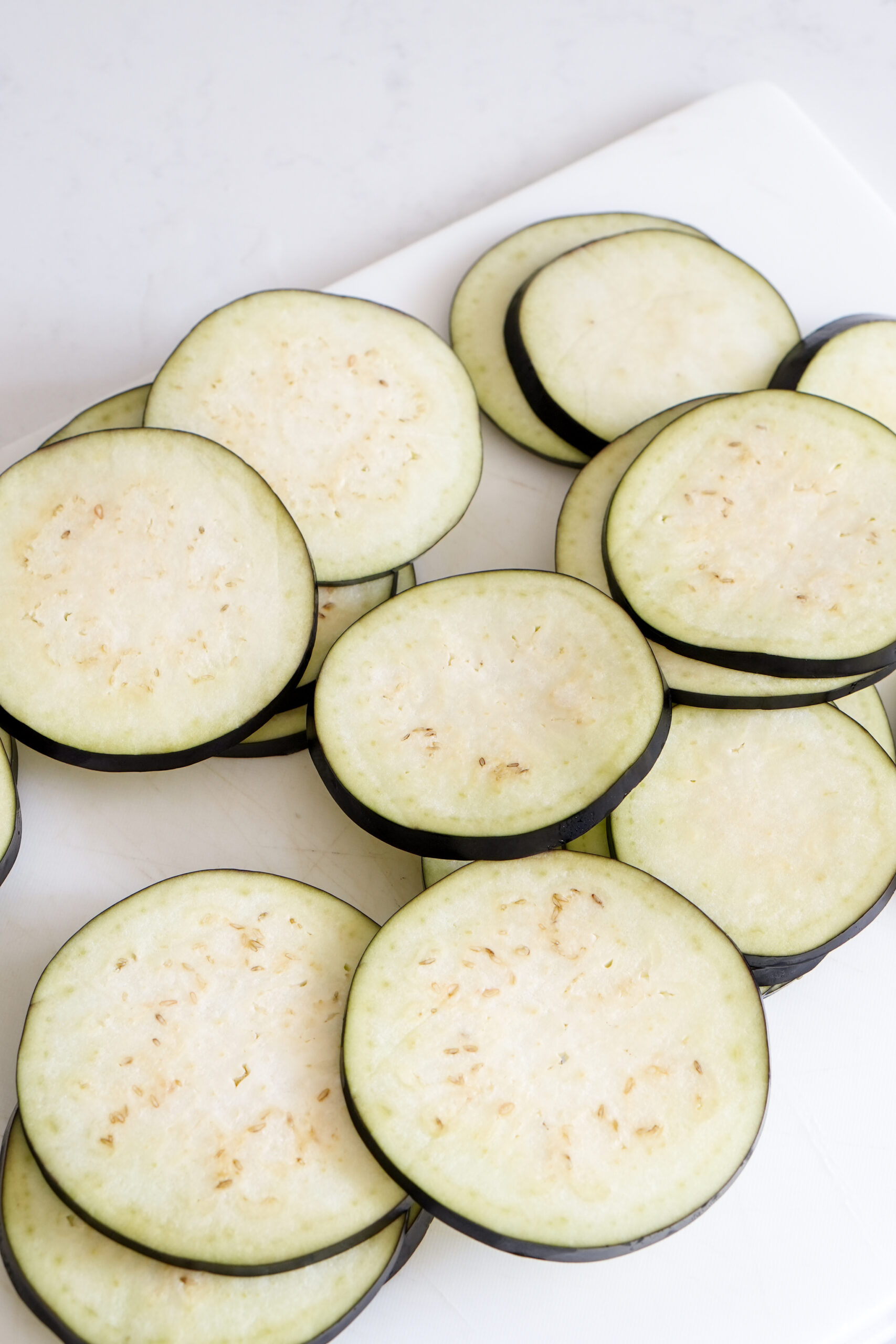 Cut up eggplant rounds on a cutting board