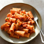 Pasta with canned tuna and tomato sauce in a bowl with a fork to the side
