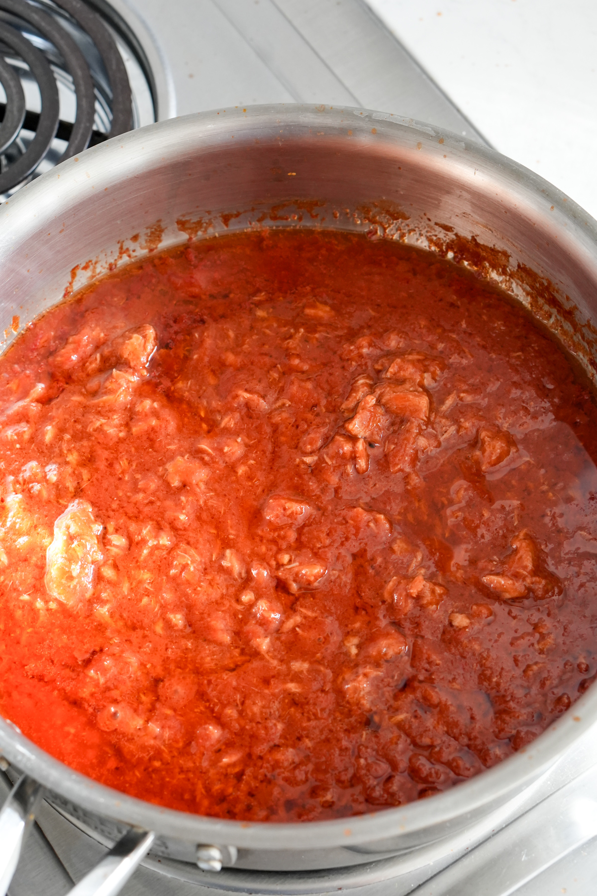 Cooked tomato sauce with canned tuna in a pan on the stove