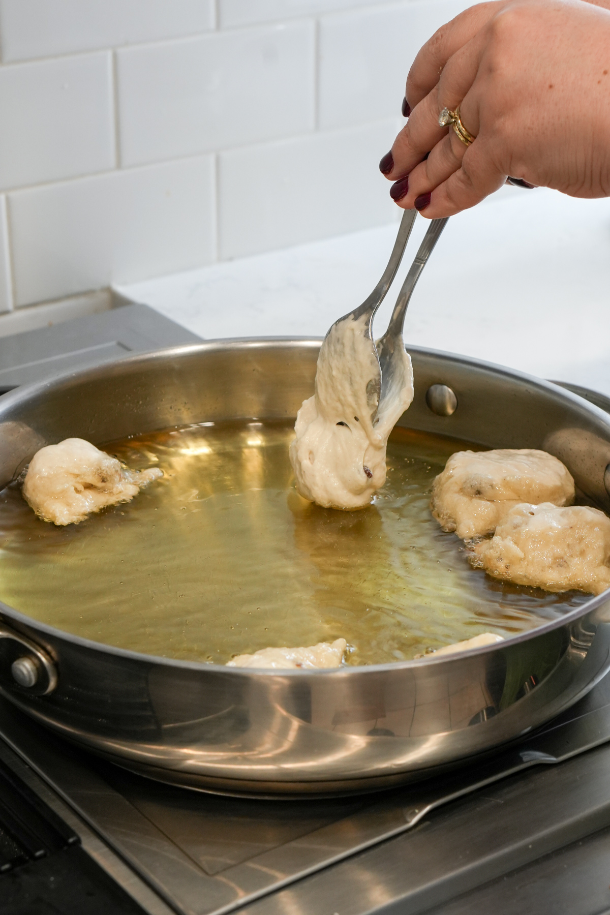 Frying zeppole - using two spoons to push dough in oil